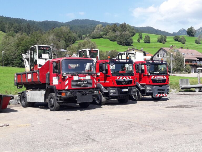 LKW-Flotte der Becherer Tiefbau GmbH mit Minibaggern auf dem Betriebsgelände im Allgäu