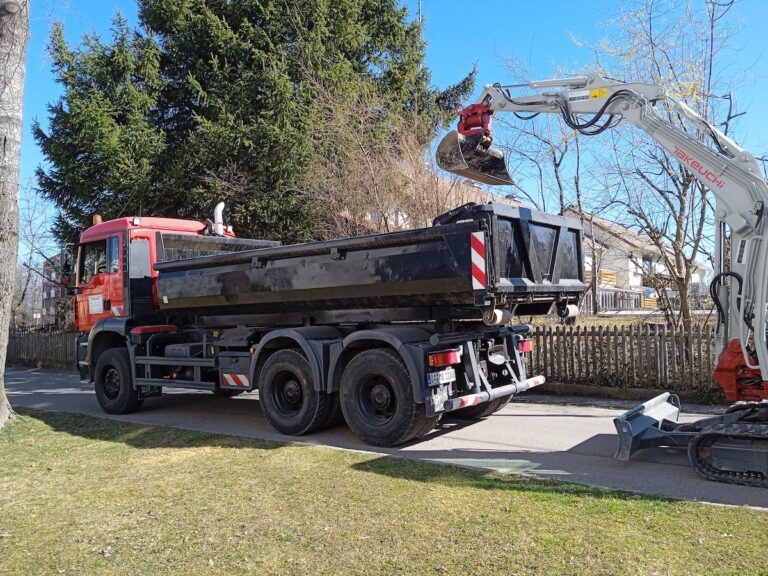 Erdbau mit Mobilbagger und Kippfahrzeug bei Tiefbauarbeiten in Wohngebiet – Becherer Allgäu